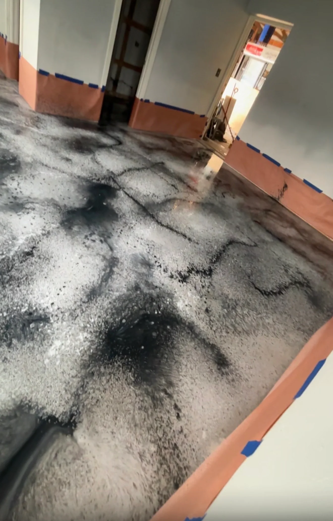 Concrete floor with fresh epoxy coating application in interior space with painted walls