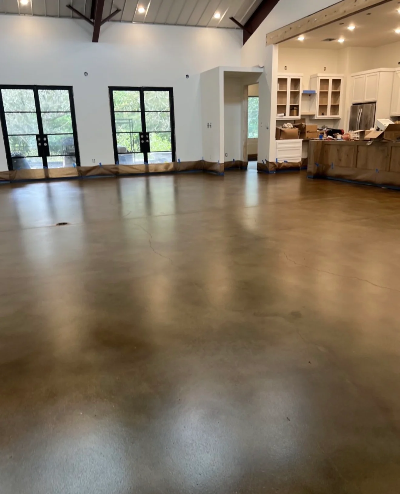 Polished concrete floor with reflective finish in open commercial space with white walls and glass doors