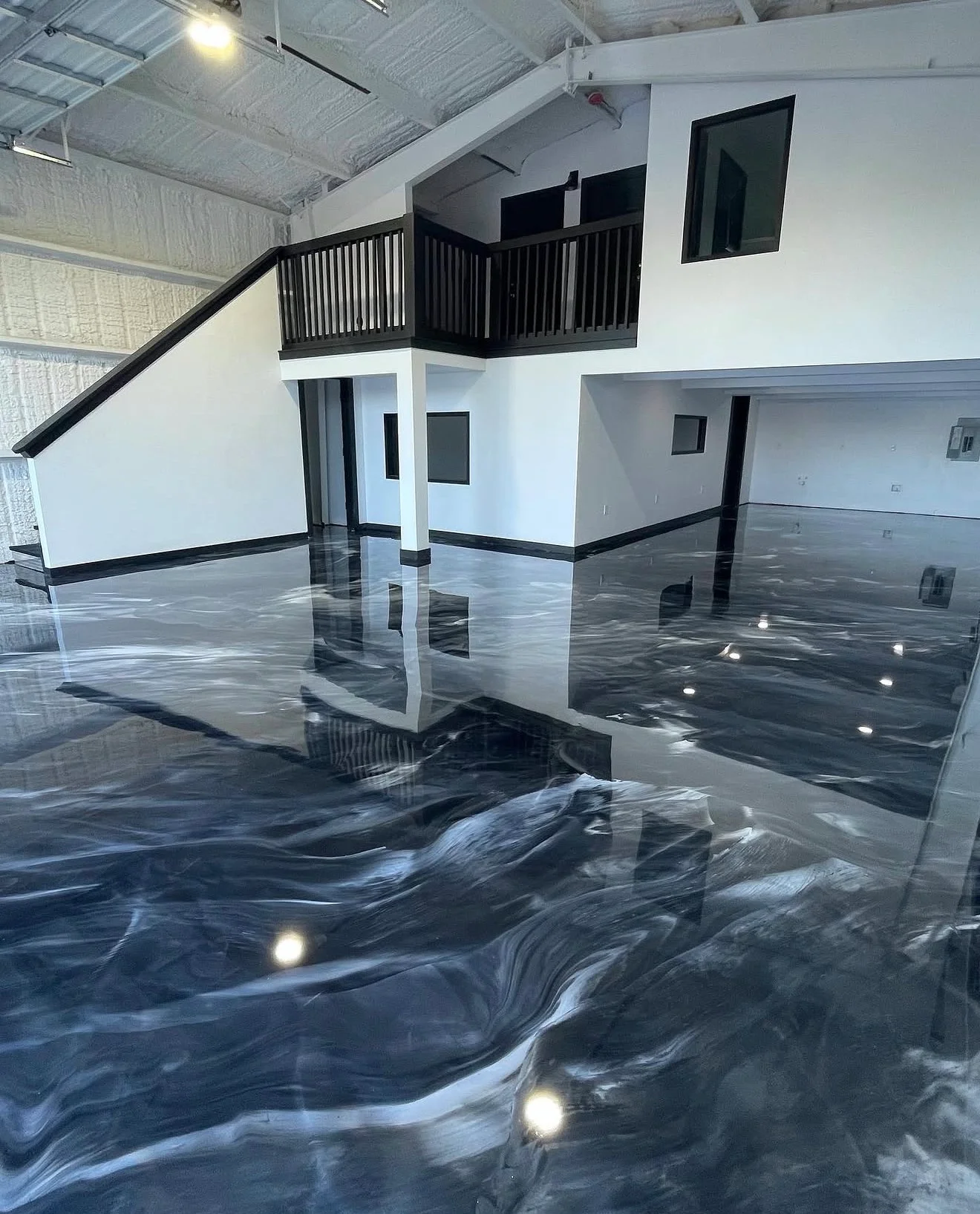 Metallic epoxy floor with blue and gray swirl pattern and embedded LED lights in warehouse space
