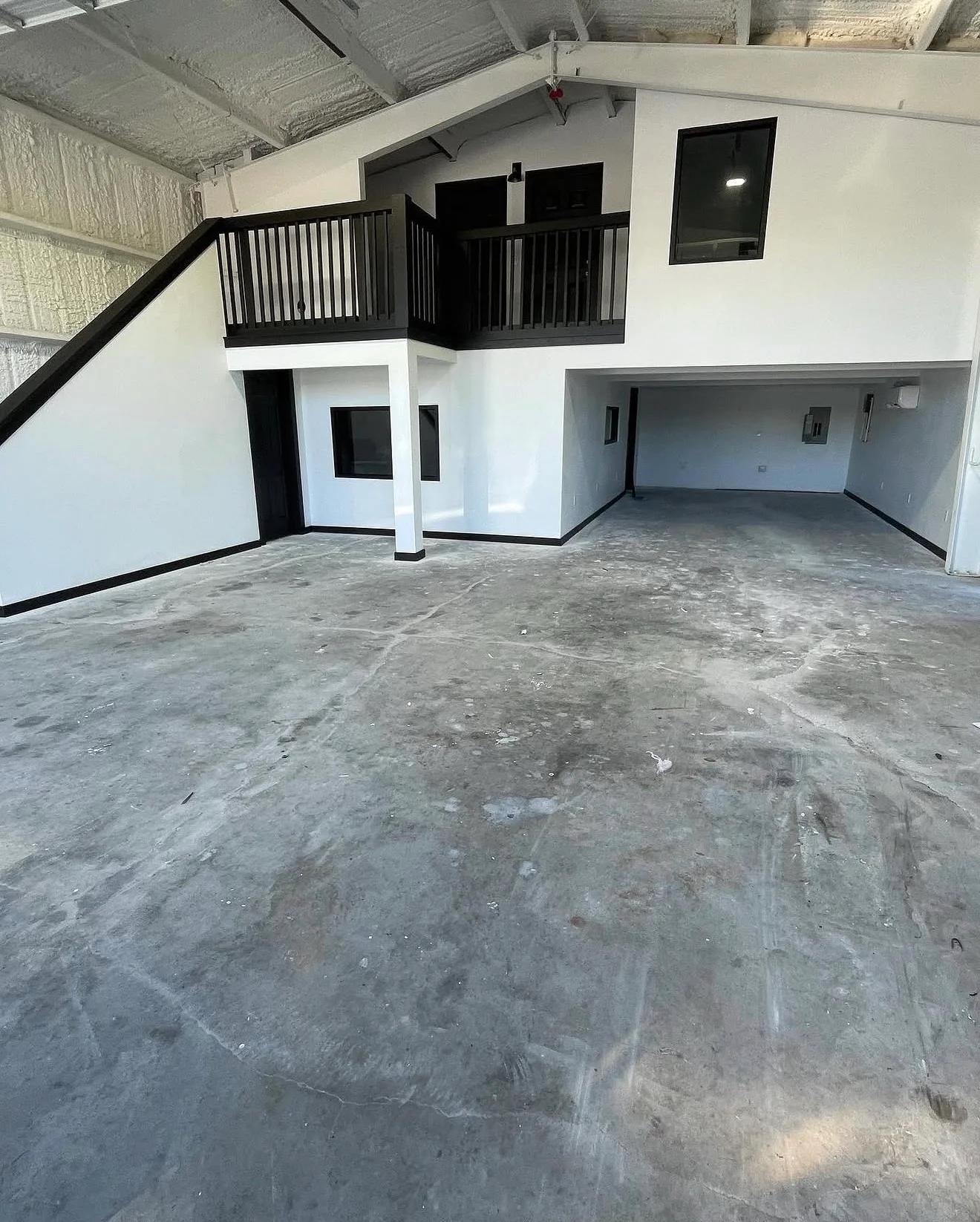 White painted drywall walls with black trim and railings in multi-level commercial interior space