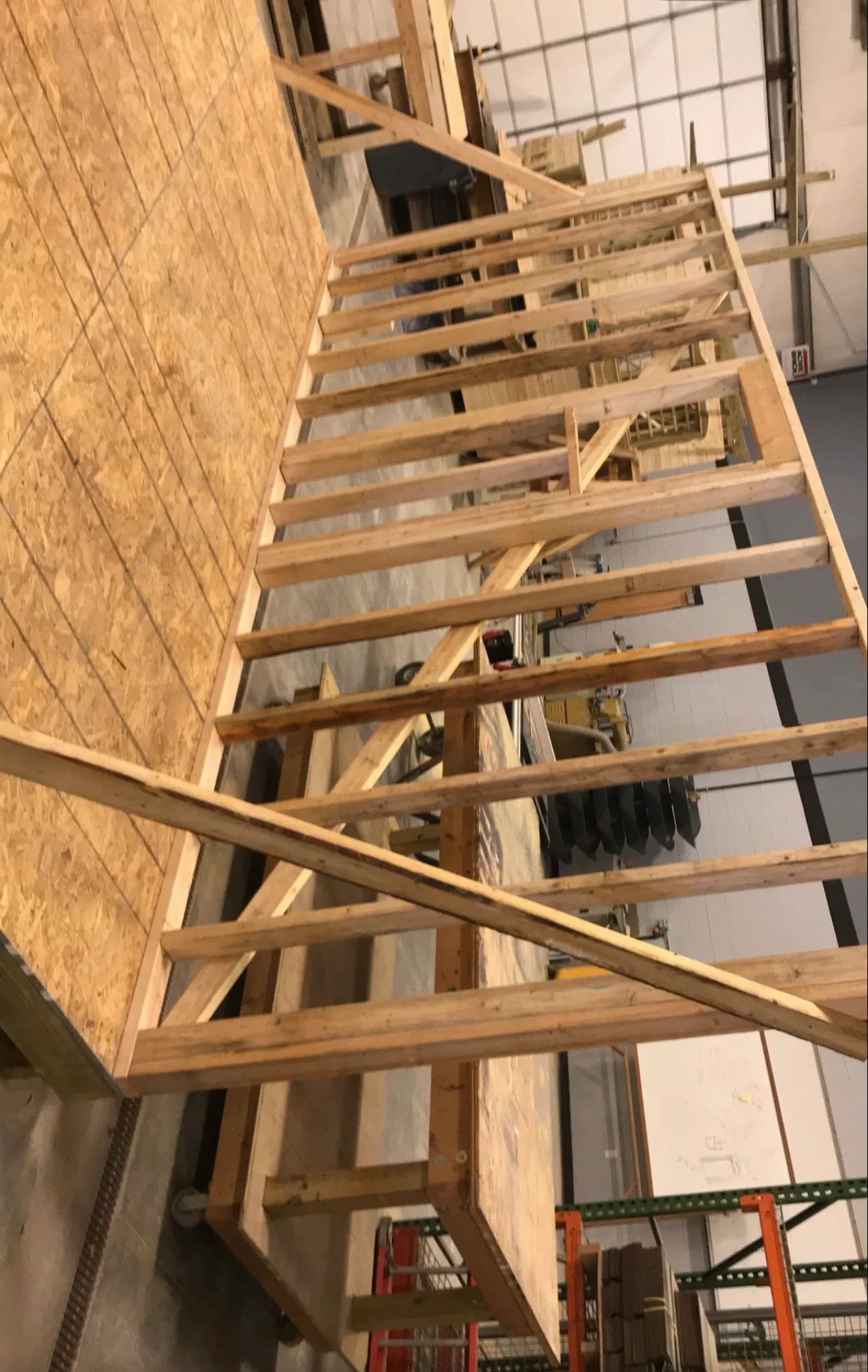 Wooden framing with installed drywall panels and structural beams in residential interior