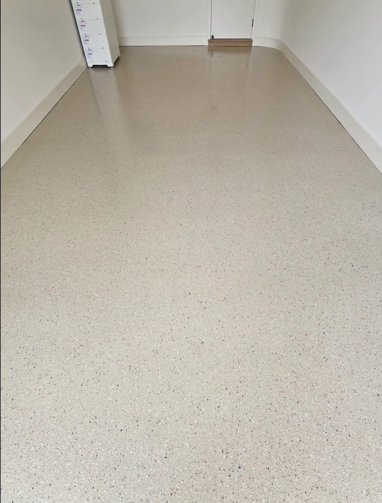 Polished concrete floor with gray epoxy coating and aggregate finish in commercial space